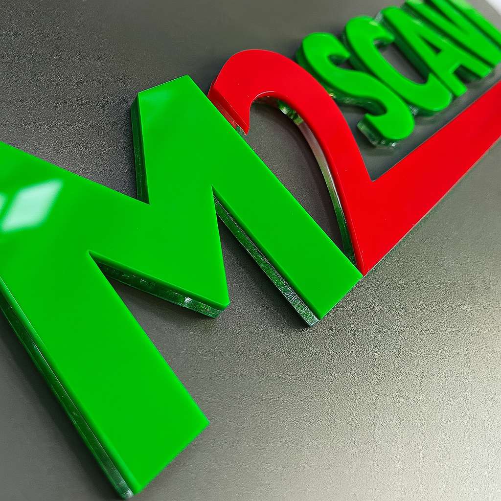 Dettaglio di lettere in plexiglass lucido tagliate al laser per M2SCAVI