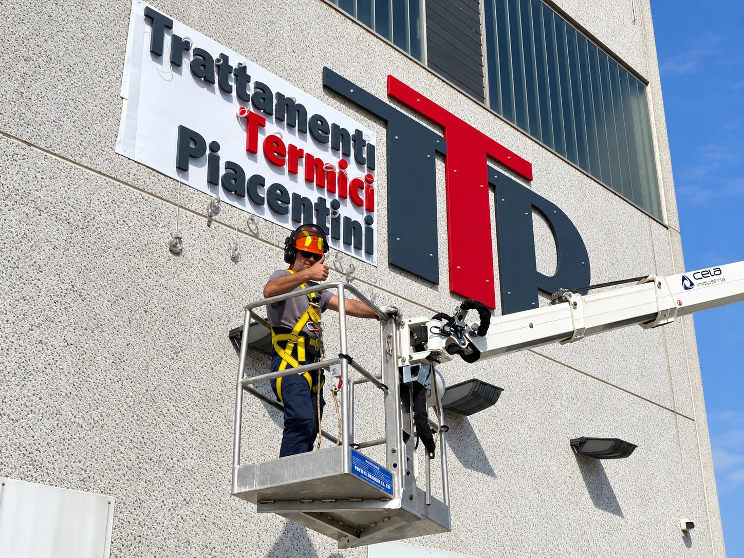 Operatore nel cestello davanti all’insegna TTP durante l’installazione