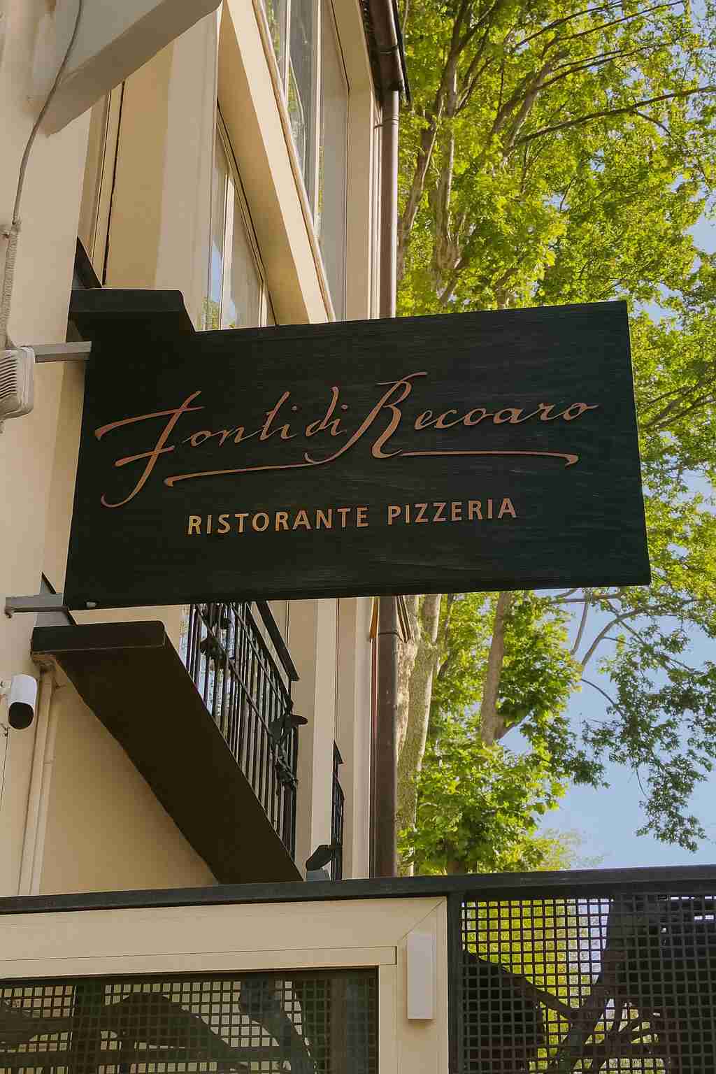 Insegna in legno scuro con scritte dorate, ideale per esterni di ristoranti e pizzerie. Eleganza e visibilità.